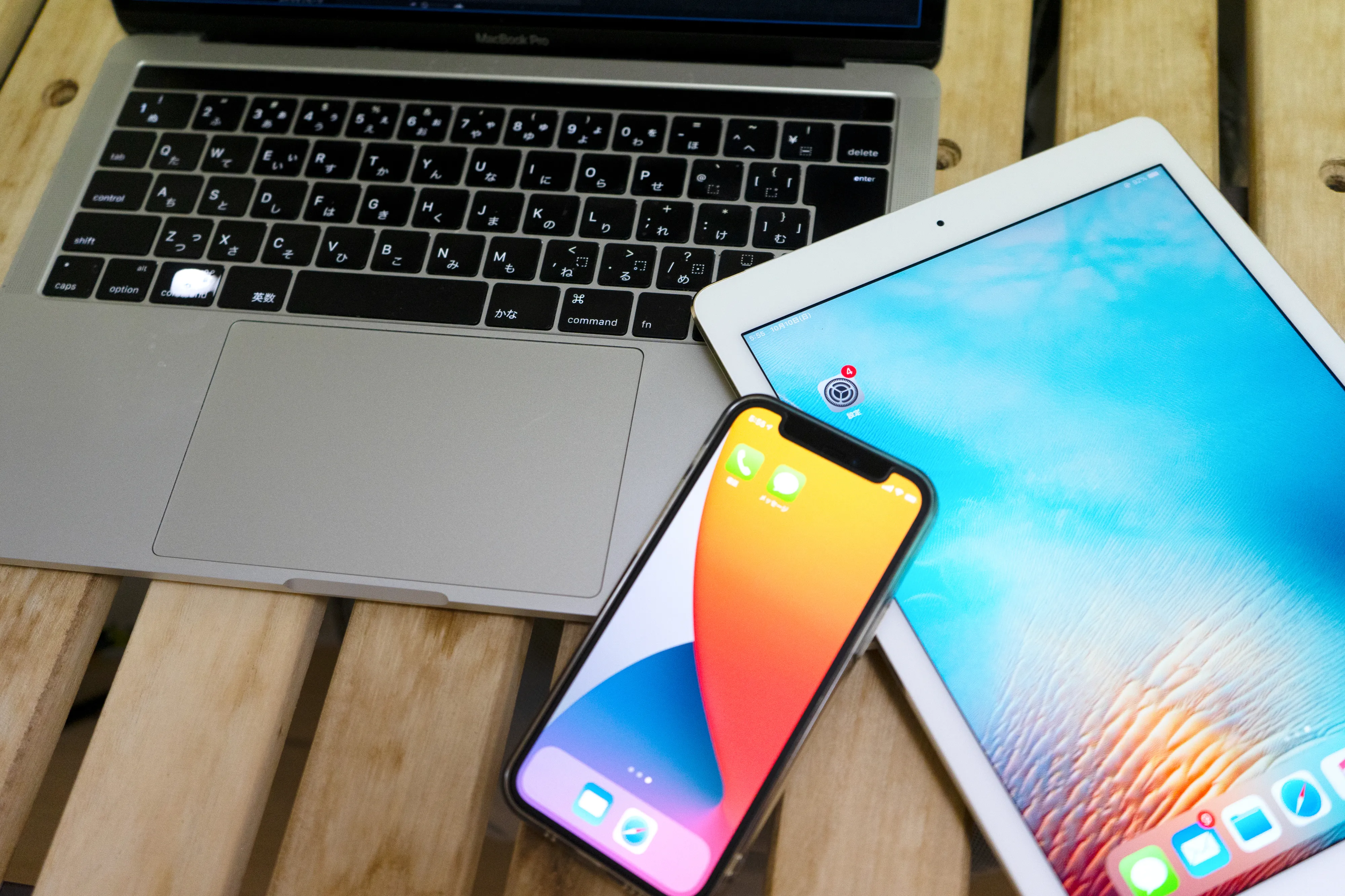 デスクにパソコン、スマートフォン、タブレットが置いてある画像